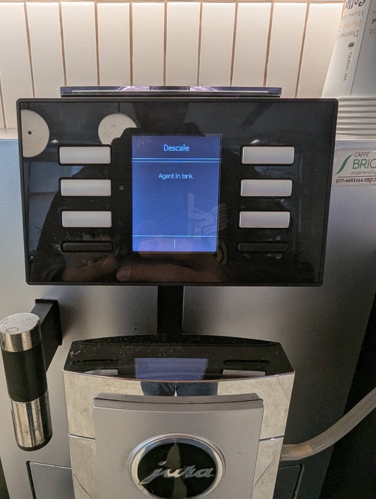 The automated Jura coffee machine in the office asking for descaling agent